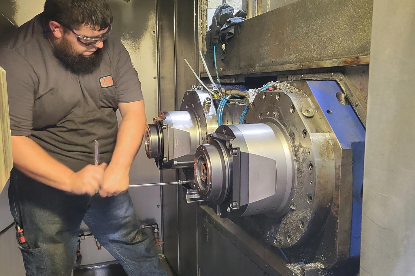 technician working on a machine component in an industrial facility